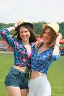 smiling girls in summer hats on the field