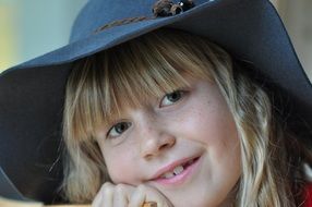 blonde smiling child girl in blue hat