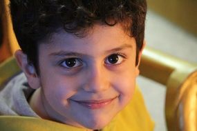 smiling boy in a yellow sweatshirt