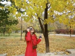 a girl with a camera on autumn background