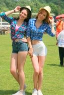 beautiful girls in hats smiling on background summer nature