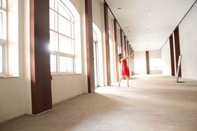 girl in red dress in empty sunny room
