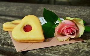 heart-shaped cookie near the rose