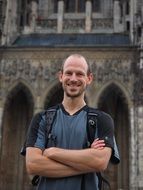 a man with a backpack on the background of the cathedral