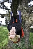 happy girl hanging upside down on tree