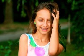 a girlie with a beautiful smile on a background of green nature