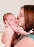 little happy baby in mom's arms