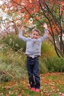 child boy playing in garden at fall