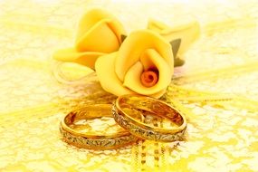 wedding rings near yellow flowers