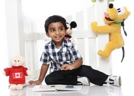 happy little boy with book and toys