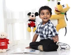 cheerful child smiling on the background of toys