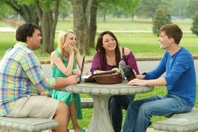 a group of students are sitting at a wooden table