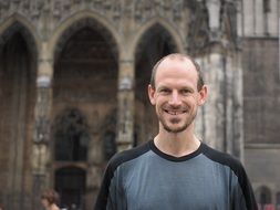 man is smiling on the background of the cathedral