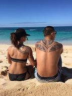 couple in love with tattoos on the beach