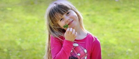 Baby girl on a background of green meadows