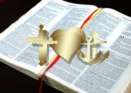 bible and images of cross , heart and anchor