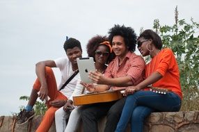 young african people with ipad and guitar