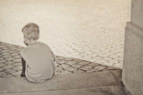 sad boy sits a monochrome image