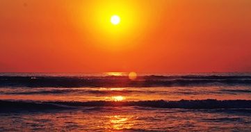 bright yellow sun over the ocean in the early morning
