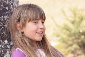 photo of a smiling girl with long hair on the nature