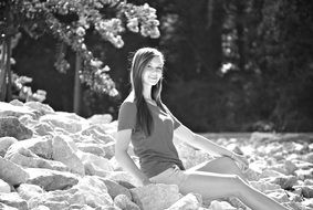 black and white photo of a girl on the rocks