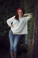 happy girl posing near a green tree