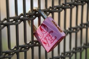 pink padlock on a fence