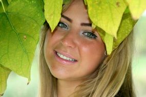 portrait of smiling girl with green leaves on her head