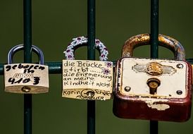 three love locks in row on metal grate