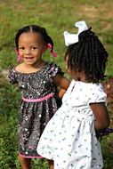 two dark-skinned girls in beautiful dresses