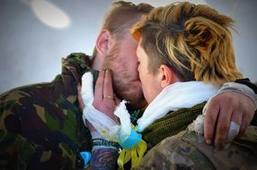 kiss of a couple in love with bandaged fingers