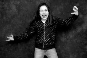 black and white photo of a crazy girl near the wall