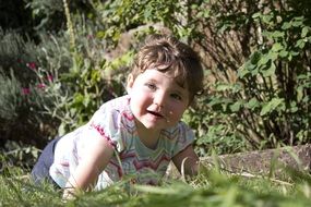 Child among the green grass in the garden