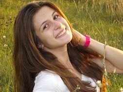 girl with long hair sitting on the grass