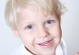 portrait of a child with white hair and a smile