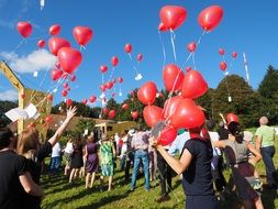 People with red balloons on wedding day