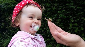 little girl laughing at a snail