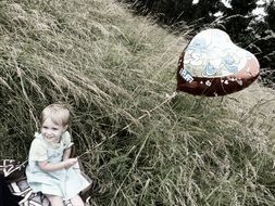 girl sitting in the grass with a heart-shaped bulb