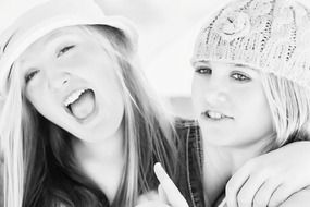 black and white photo of two girlfriends in hats