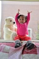 happy girl in a pink blouse and teddy bear