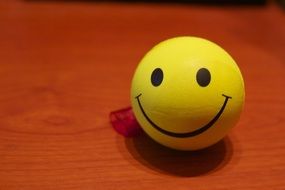 smiling yellow ball at red background