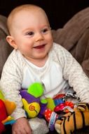 cheerful baby with colorful soft toys
