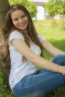 Portrait of the smiling girl near the tree