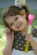 smiling girl with soap bubbles bottle