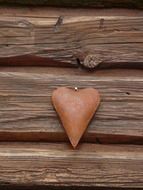 metal figurine of a heart on a wooden wall