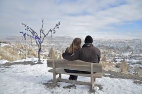 couple in love sitting on a wooden bench