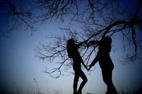 silhouettes making heart by hands