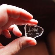 glass with letters in hand, love never fails