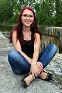 girl with red hair sitting on a stone