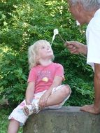 girl playing with her father outside